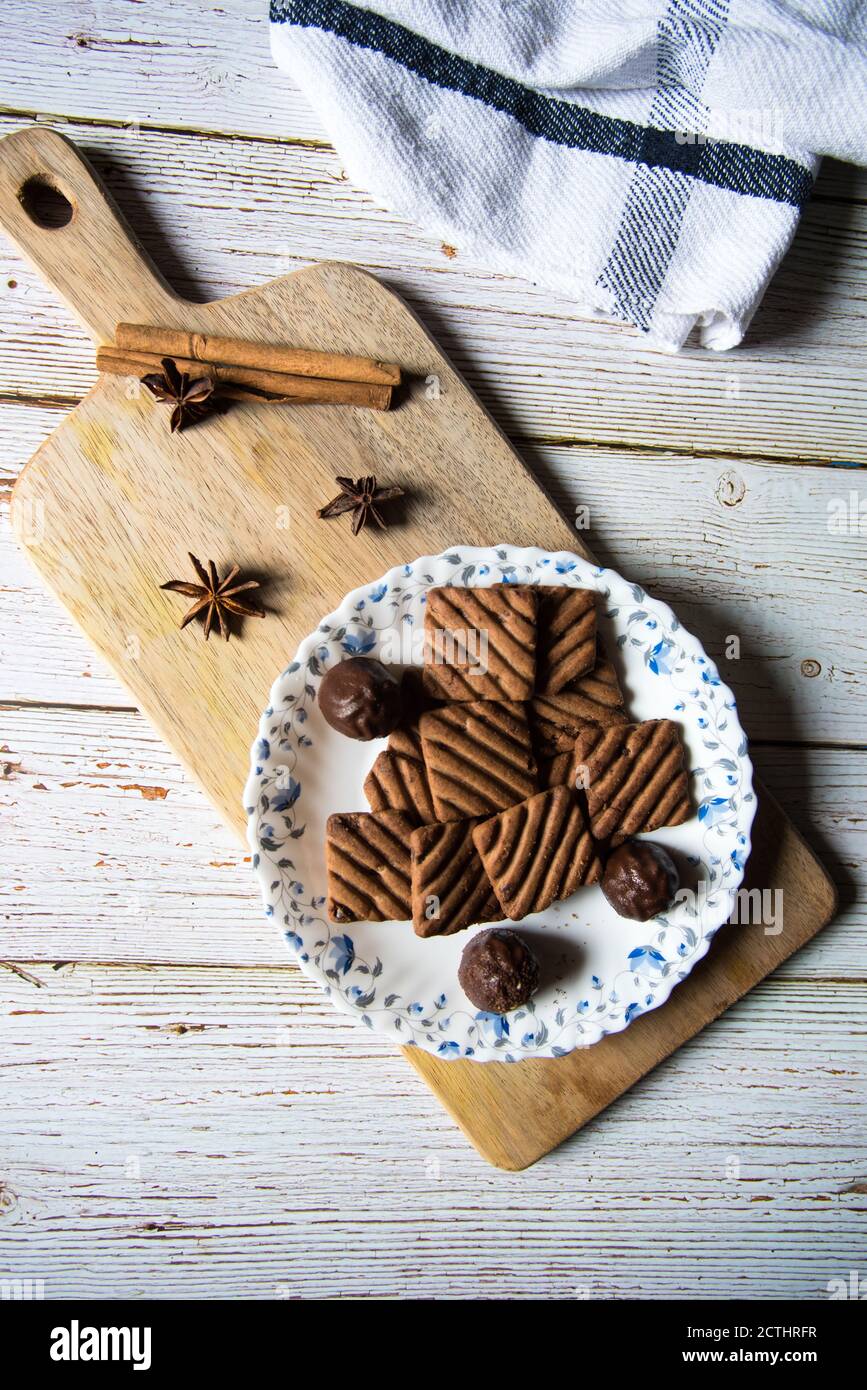 Leckere Schokoladenkekse und Pralinen auf einer Holzplatte Ein Hintergrund Stockfoto