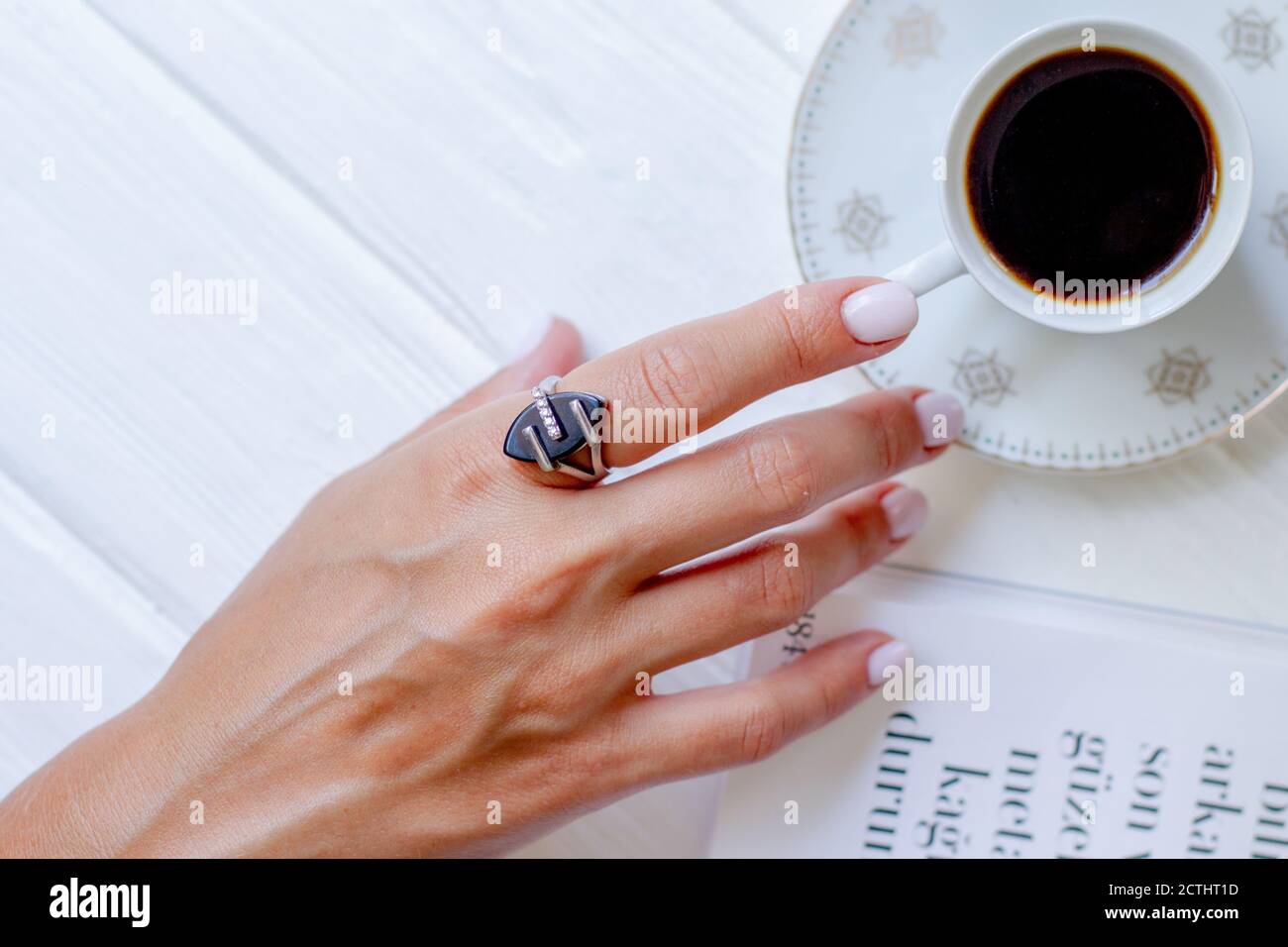 Keramik Tasse Kaffee mit Blumen in Frauen gut gepflegte Hände mit Maniküre. Stockfoto