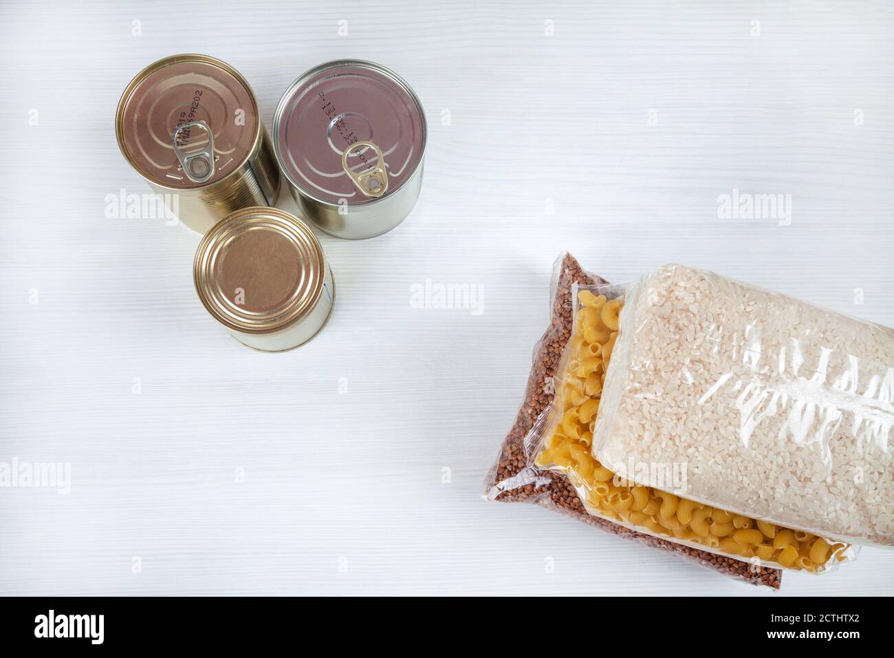 humanitarian assistance for poor and large families. Donation during crisis. Tin cans, canned food, stew, buckwheat, rice, pasta in transparent bags Stockfoto