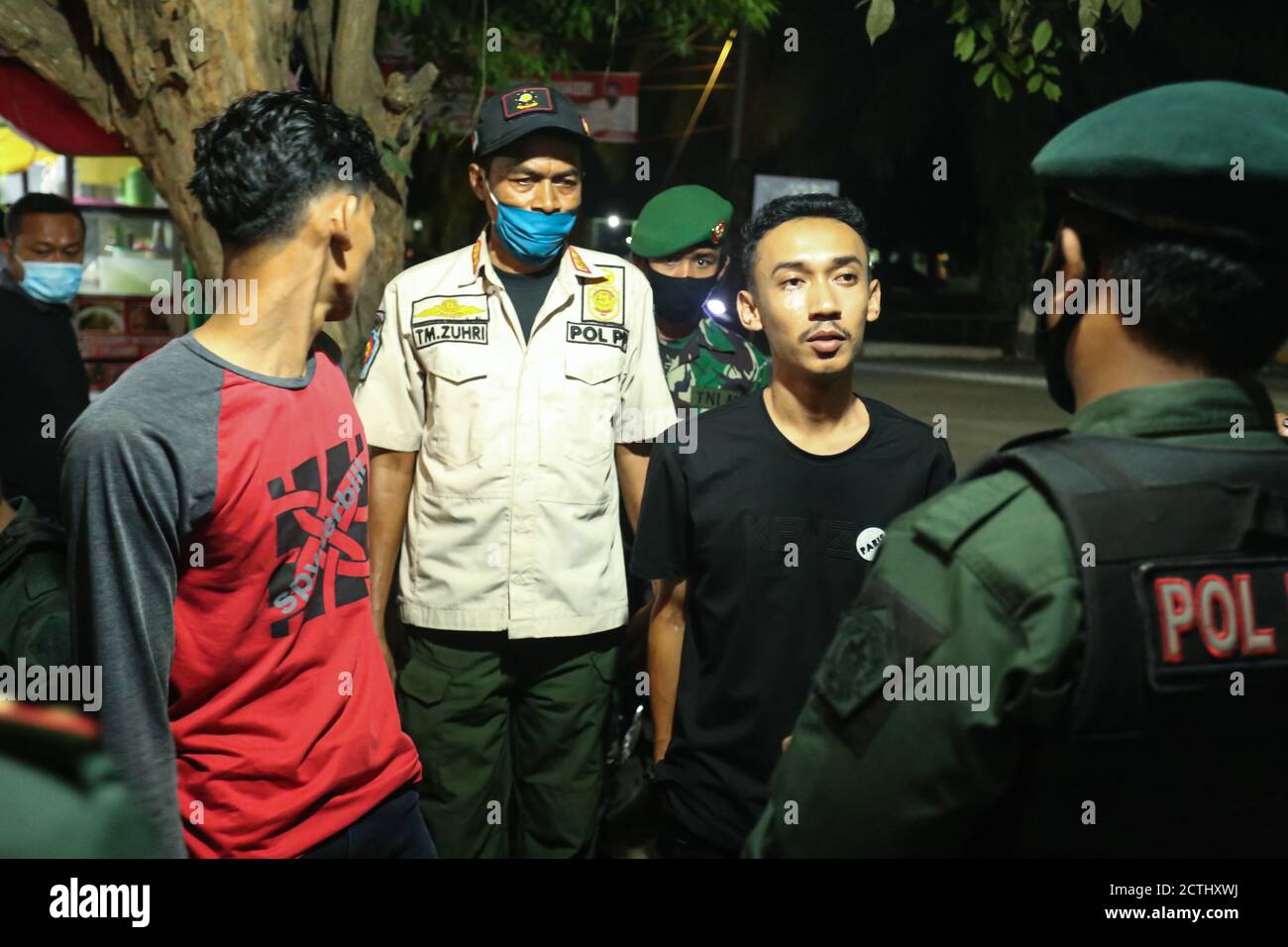 Beratung des COVID-19 Gesundheitsprotokolls durch die Regierung der Stadt Lokseumawe an die Bewohner von Lhokseumawe, Aceh, Indonesien, für diejenigen, die keine Masken in einem Café im Sp.Buloh Bereich um Mitternacht Ortszeit tragen, Mittwoch, 23. September 2020. Stockfoto