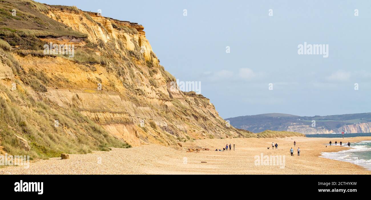 Blick auf EINE Sandsteinklippe von Hengistbury Head und Strand mit Menschen zu Fuß, Christchurch UK Stockfoto