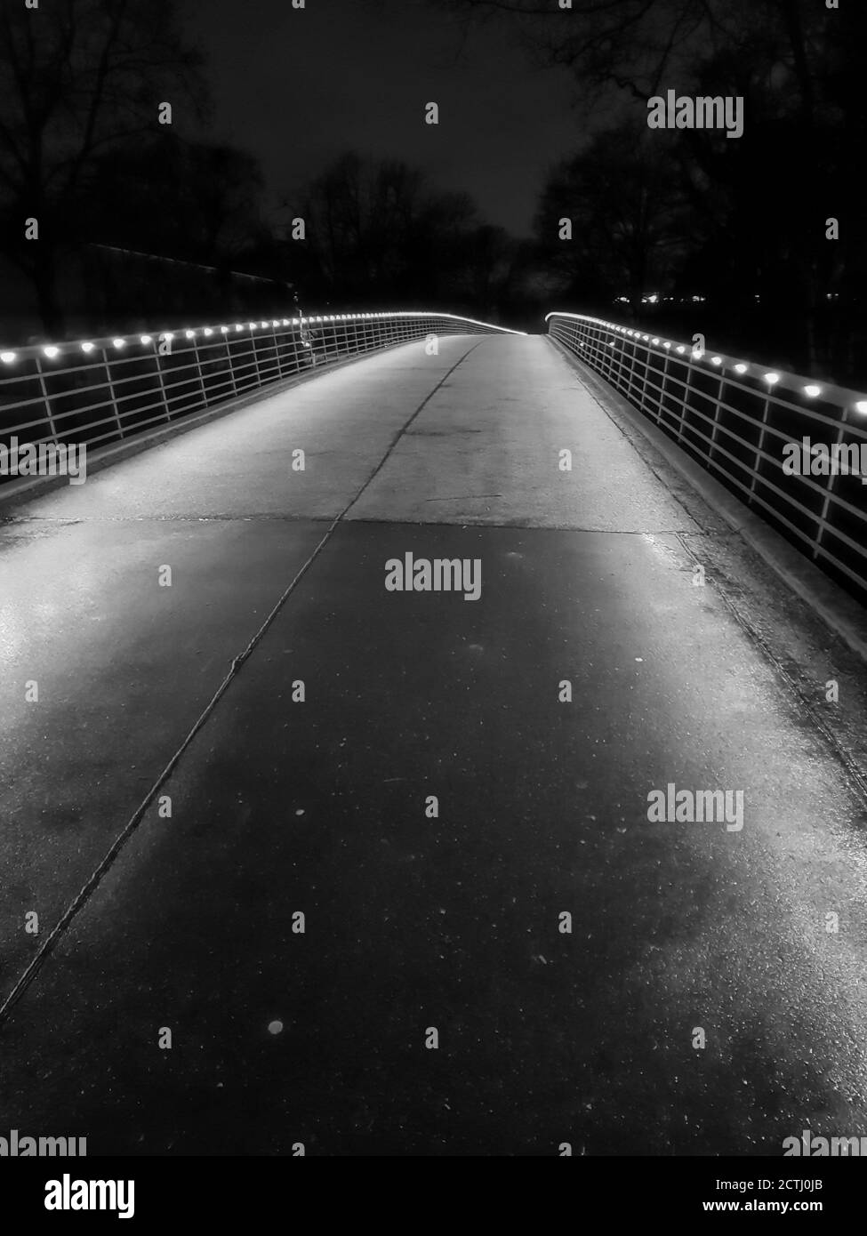 Beleuchtete Brücke in einem Park in der Nacht Stockfoto