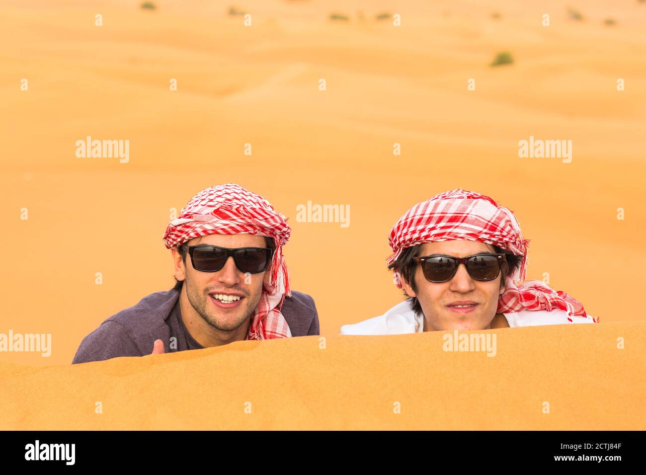 Zwei glückliche männliche Touristen genießen eine Safari-Tour in der arabischen Wüste Sanddünen. Reisen und Tourismus. Stockfoto