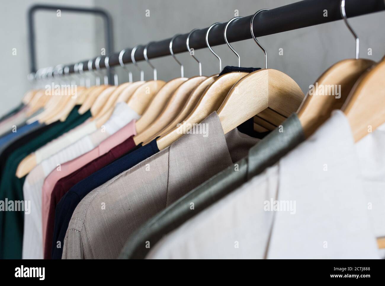 Sammlung von High-Fashion-Kleidung, die auf einem Kleiderständer in einem Einzelhandelsgeschäft hängt. Stockfoto