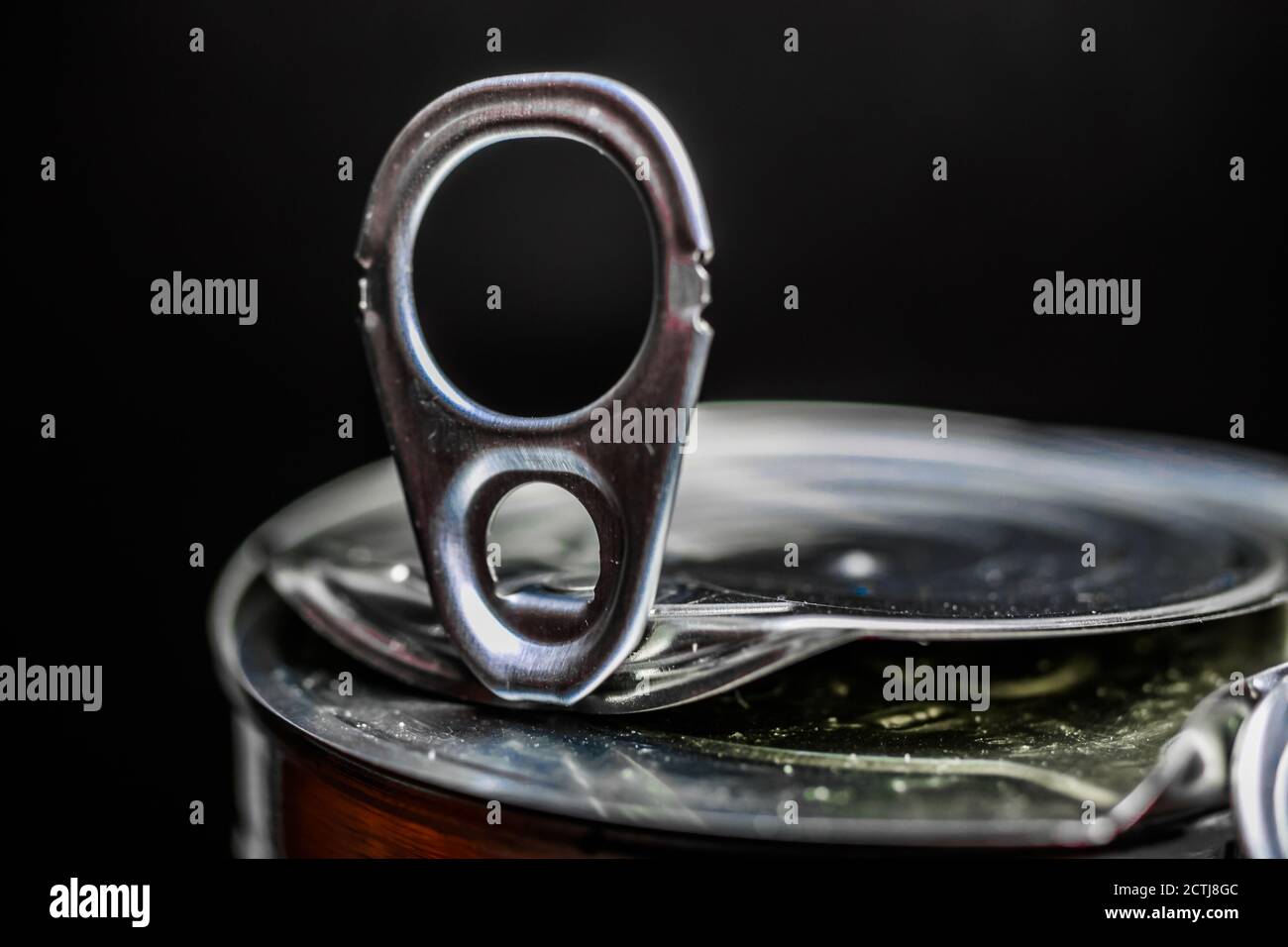 Makro-Nahaufnahme von isolierten glänzenden Metall-Lebensmittelkaknen mit schwarz Hintergrund (Fokus auf der Mitte der Zuglasche) Stockfoto