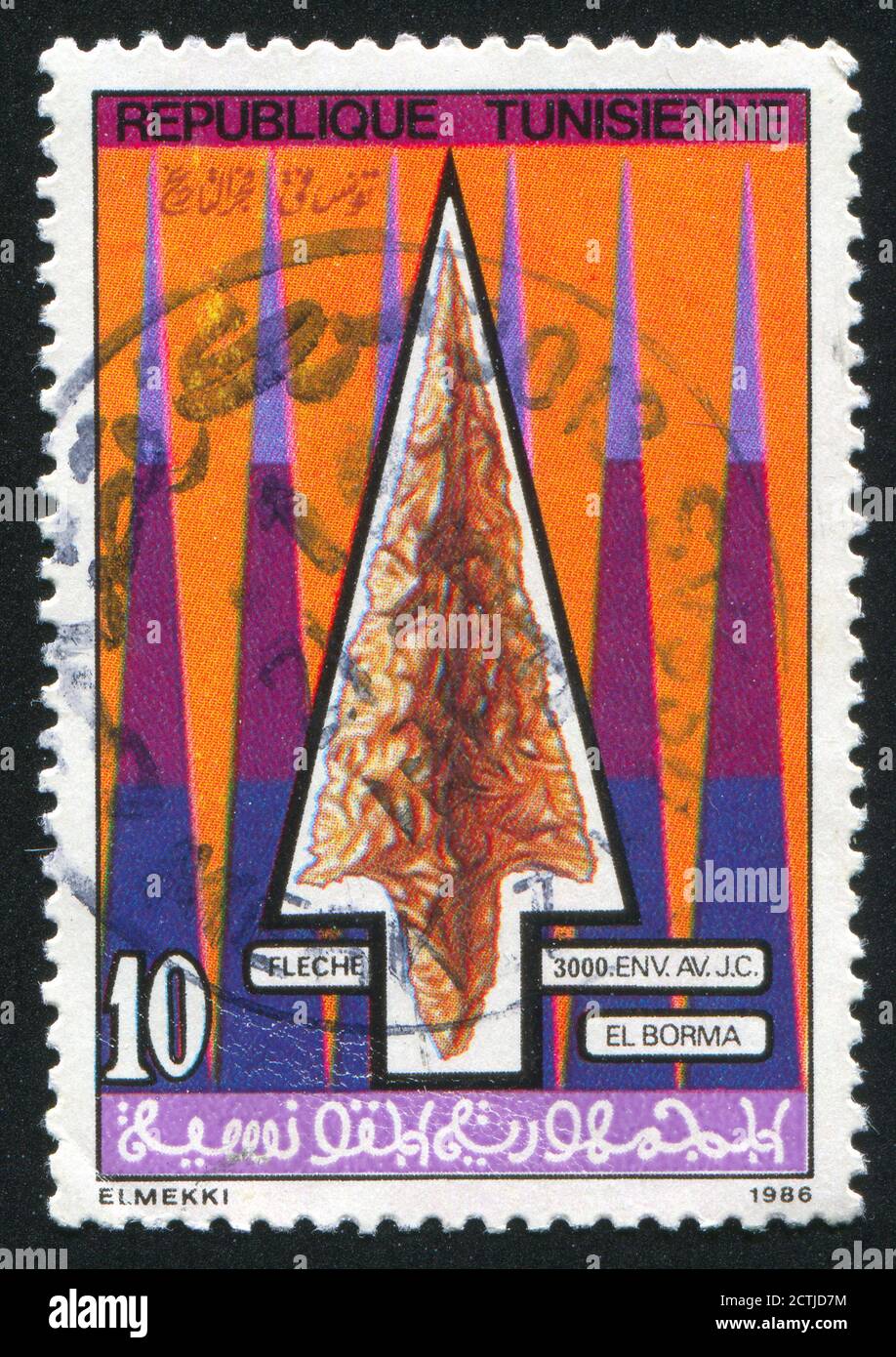 TUNESIEN - UM 1986: Briefmarke gedruckt von Tunesien, zeigt protohistorische Artefakte, Flint Pfeilspitze, um 1986 Stockfoto