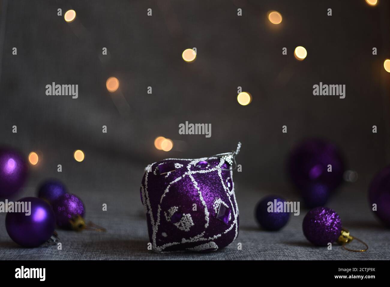 Weihnachten Spielzeug Bälle von grau lila Farbe auf einem grau Fabric-Hintergrund Stockfoto