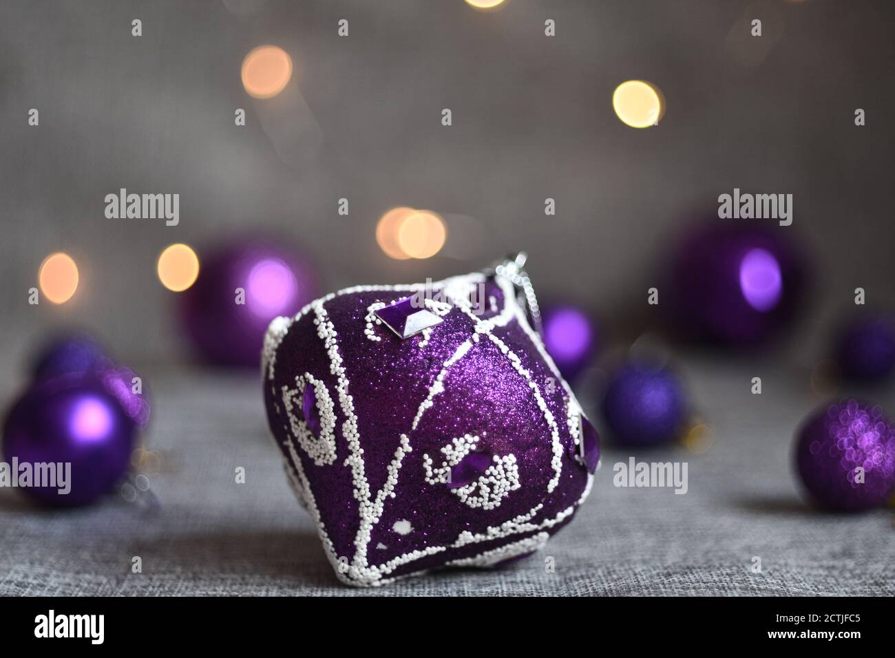 Lila weihnachtskugeln Nahaufnahme auf grauen Stoff Hintergrund Stockfoto
