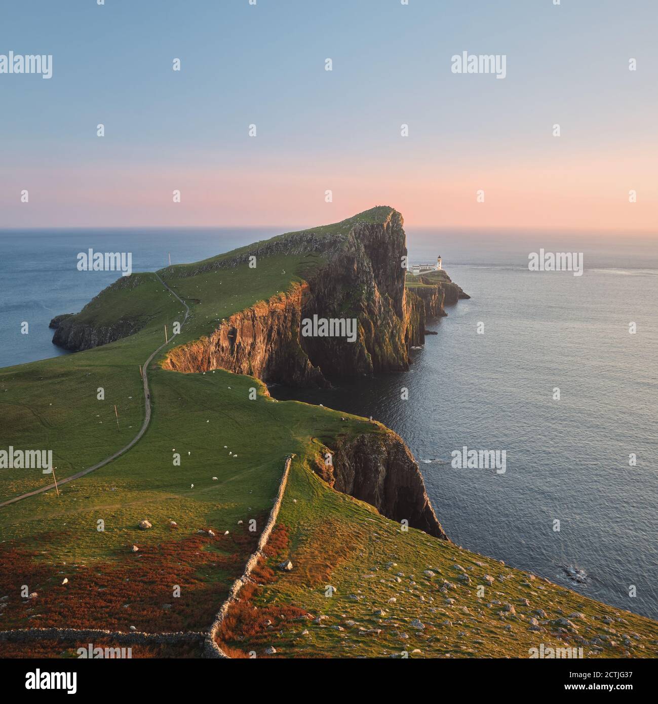 Eine Schminkerei eines feinen Leuchtturms, der auf einer atemberaubenden Klippe vor dem Hintergrund des Meeres steht und von der untergehenden Sonne beleuchtet wird. Neist Point, Isle of Skye, Schottland Stockfoto