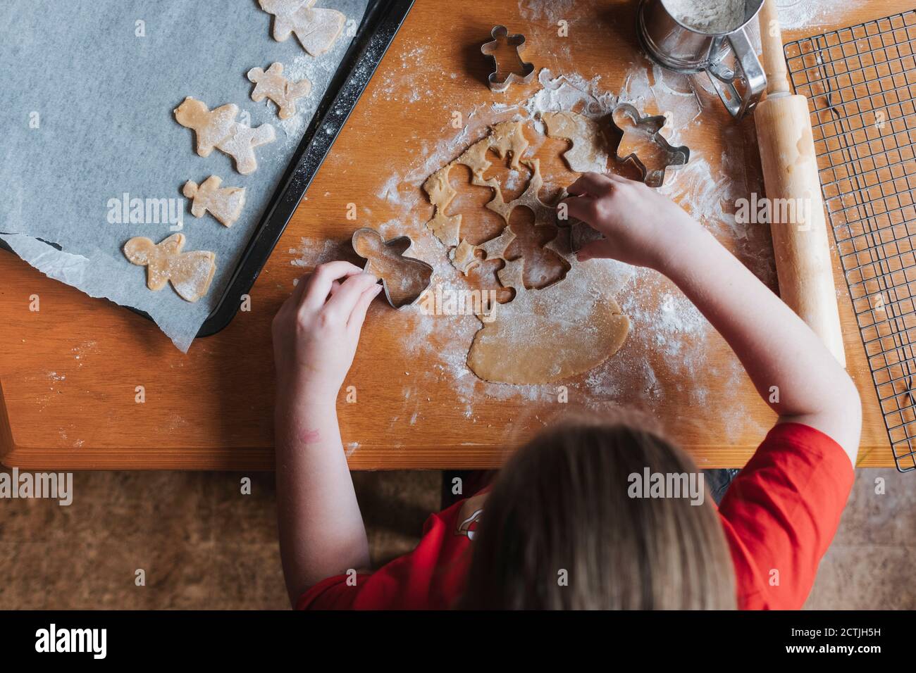 Overhead-Ansicht eines Mädchens mit Ausstechformen zu machen Lebkuchenmann Stockfoto