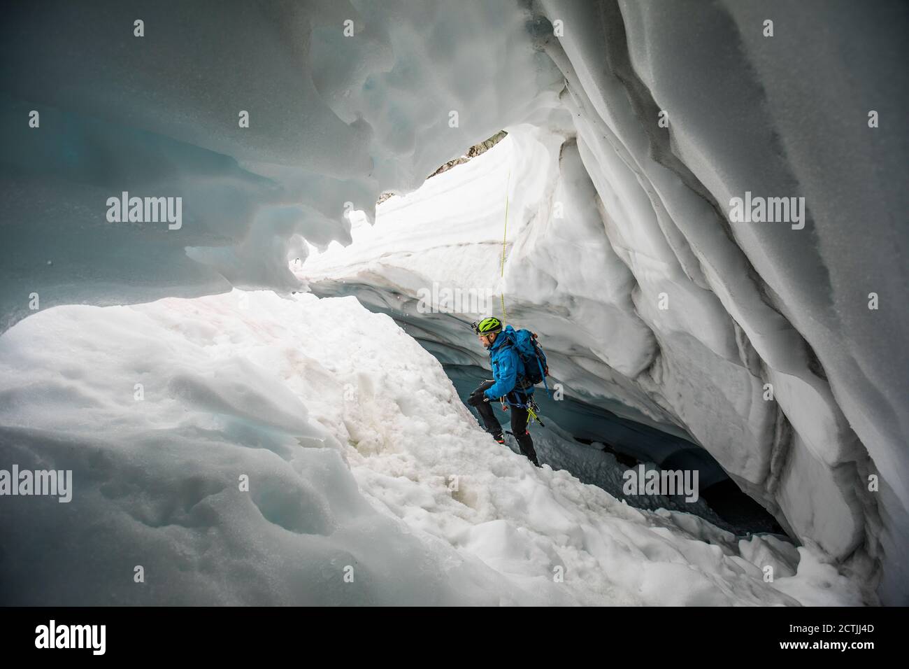Bergsteiger klettert aus der Gletscherhöhle in der Nähe, Coast Mountains, B.C. Stockfoto