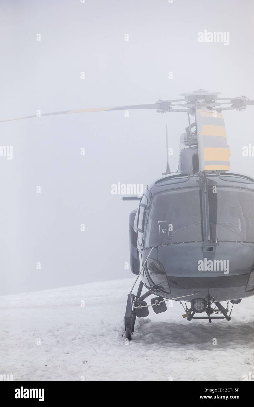 Hubschrauber landete auf schneebedeckten Berggipfel. Stockfoto
