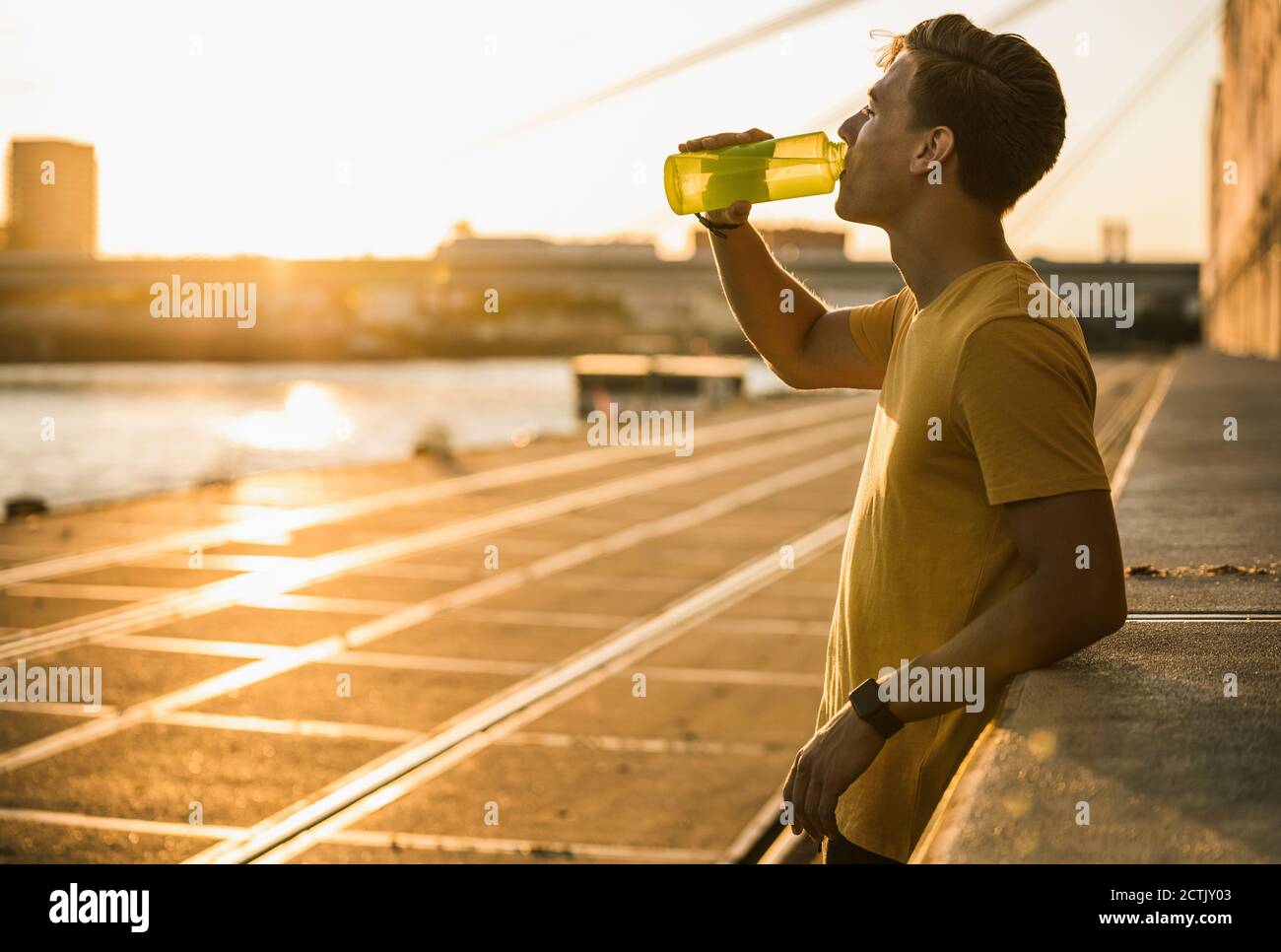 Mann Trinkwasser nach dem Training gegen klaren Himmel Stockfoto