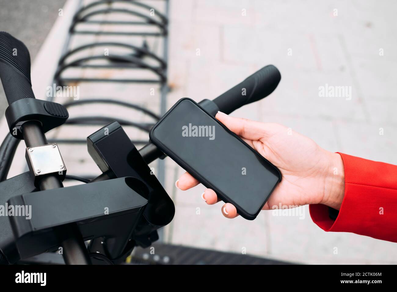 Hand der weiblichen professionellen Scannen QR-Code auf elektrischen Push Roller von Smartphone Stockfoto