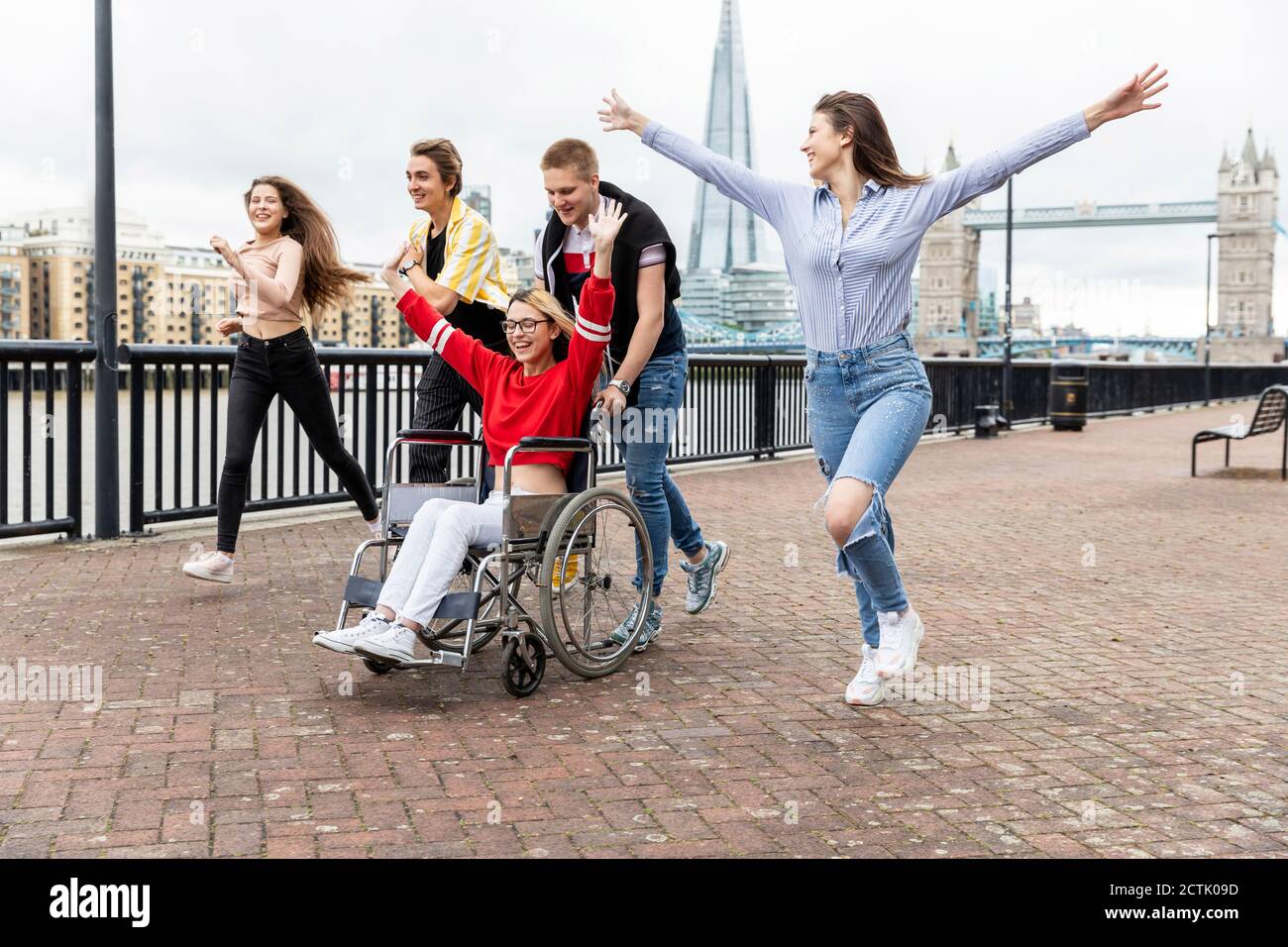Unbeschwerte Männer und Frauen mit behinderten weiblichen Freunden verbringen Freizeit in der Stadt, London, Großbritannien Stockfoto
