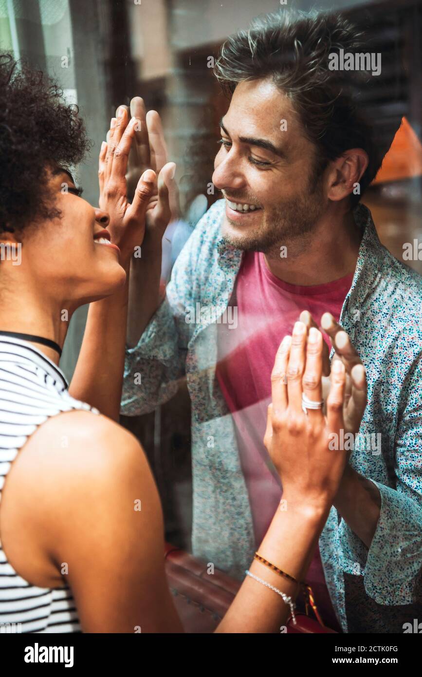 Nahaufnahme einer Frau, die durch das Café einen lächelnden Freund ansieht Angezeigt Stockfoto