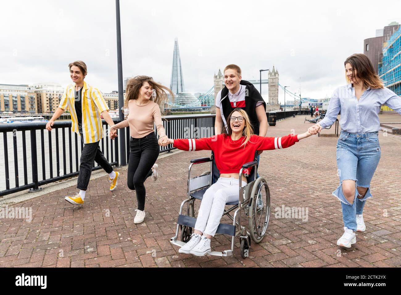 Fröhliche Männer und Frauen mit behinderten weiblichen Freund genießen in der Stadt, London, Großbritannien Stockfoto