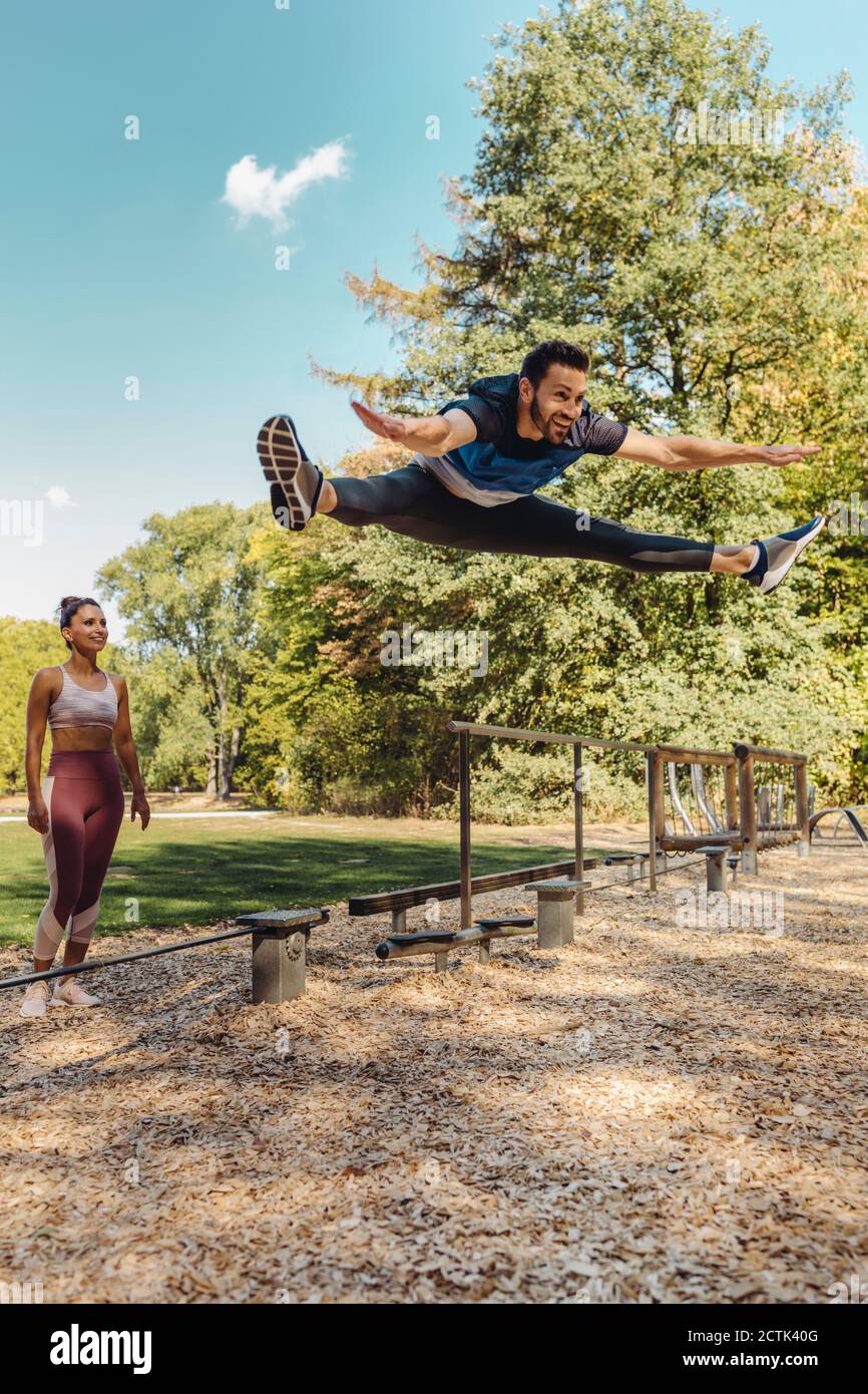 Mann springt mitten in der Luft auf einem Fitness-Parcours Stockfoto