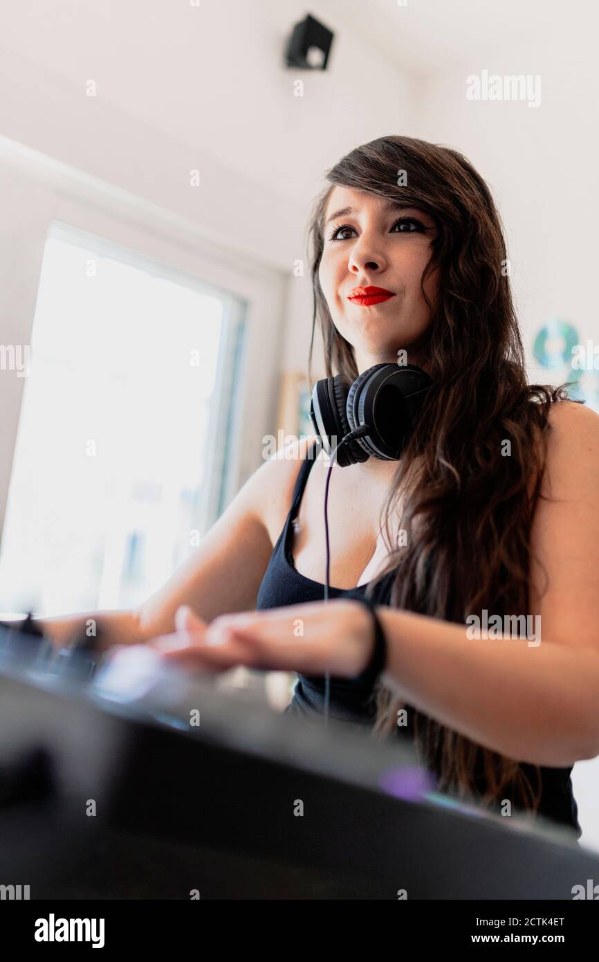 Weibliche Musikproduzentin mit Tonaufnahmesequipment im Studio Stockfoto