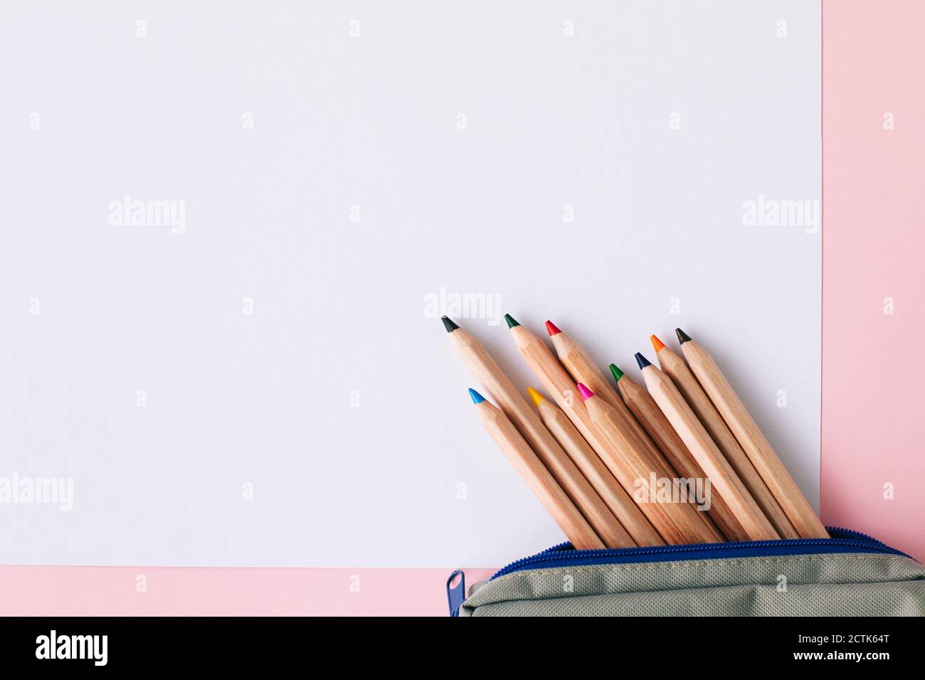 Buntstifte im Beutel auf weißem Papier über rosa Hintergrund Stockfoto