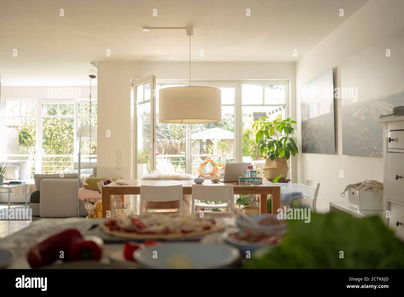 Wohnzimmer mit Esstisch gegen Tür und Fenster während Sonniger Tag Stockfoto