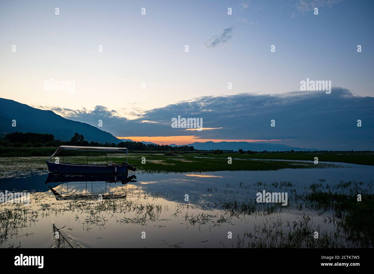 Leeres Boot schwimmt im Kerkini See bei Sonnenaufgang, Mazedonien, Griechenland Stockfoto