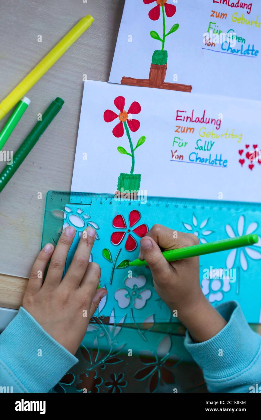 Zugeschnittenes Bild von Mädchen Hände Zeichnung Blumen auf Papier bei Tabelle Stockfoto
