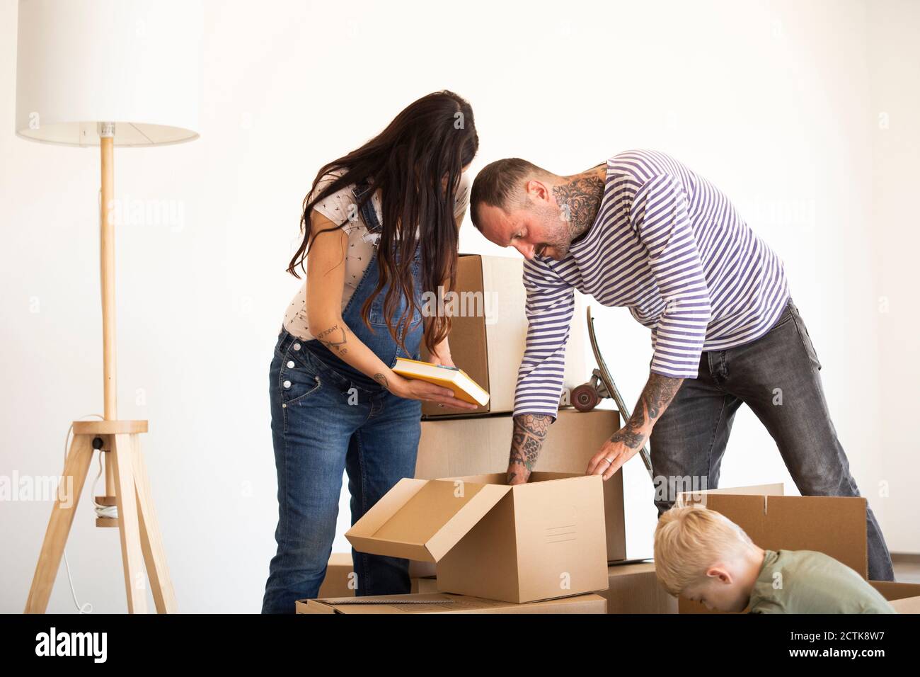 Familie Auspacken Pappkartons gegen die Wand im neuen Haus Stockfoto