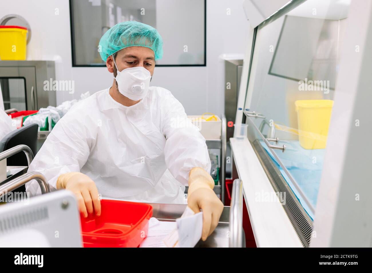 Männlicher Arzt mit Behälter und Rezept auf Push-Cart arbeiten In der Apotheke Stockfoto