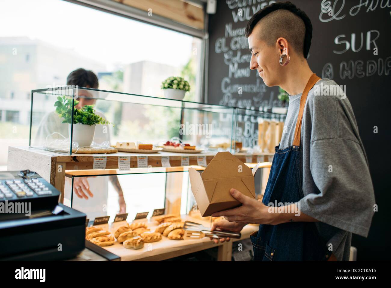 Kellner und Kunde an der Theke in einem Café Stockfoto