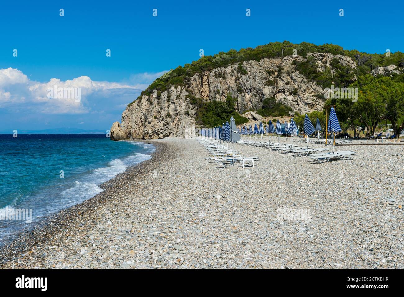 Griechenland, Nord-Ägäis, Reihen von Sonnenschirmen und leeren Liegestühlen am Strand von Tsambou im Sommer Stockfoto