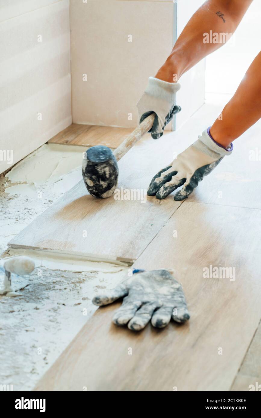 Mann hämmerte Holz auf Zement auf der Baustelle Stockfoto