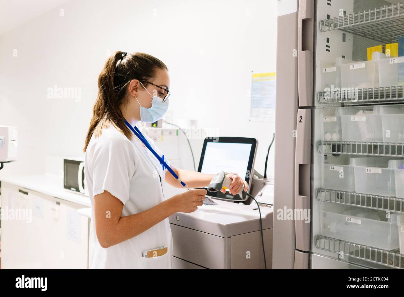 Ärztin Scannen id-Karte, während in der Apotheke zu stehen Krankenhaus Stockfoto