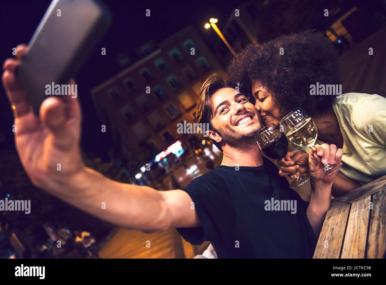Frau küssen Freund nehmen Selfie bei Datum Nacht Stockfoto