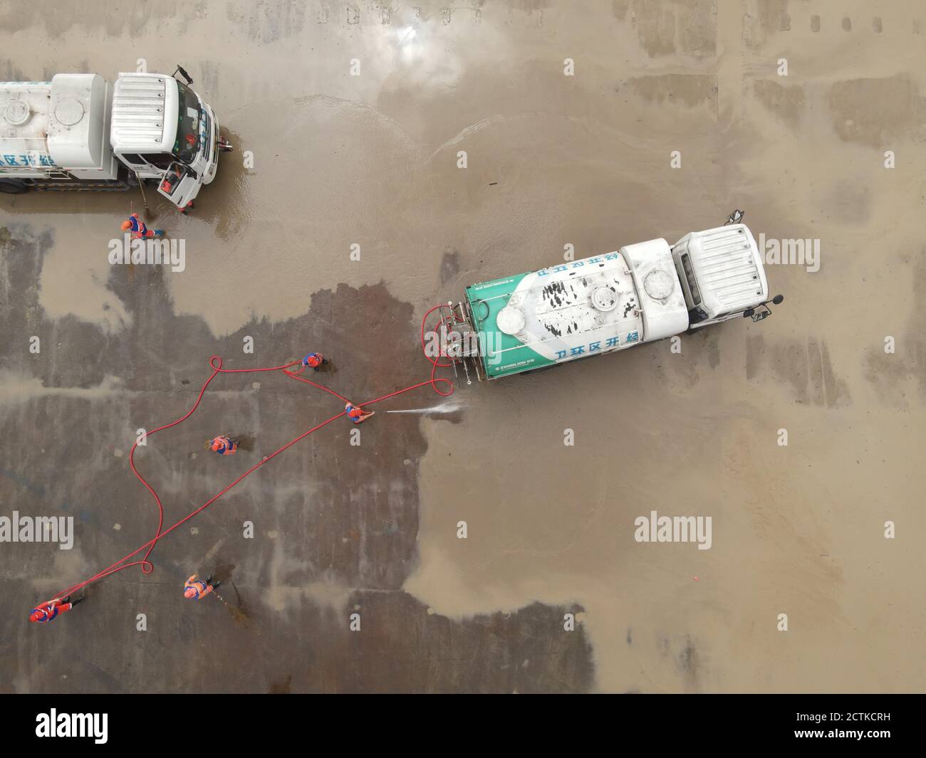 Eine Luftaufnahme von 15 Bewässerungs-LKW und einem Abfallentsorgungsstamm eingesetzt, um eine Schiffsfabrik, die durch die schwere Flut beeinflusst wurde, zu reinigen Th zu helfen Stockfoto