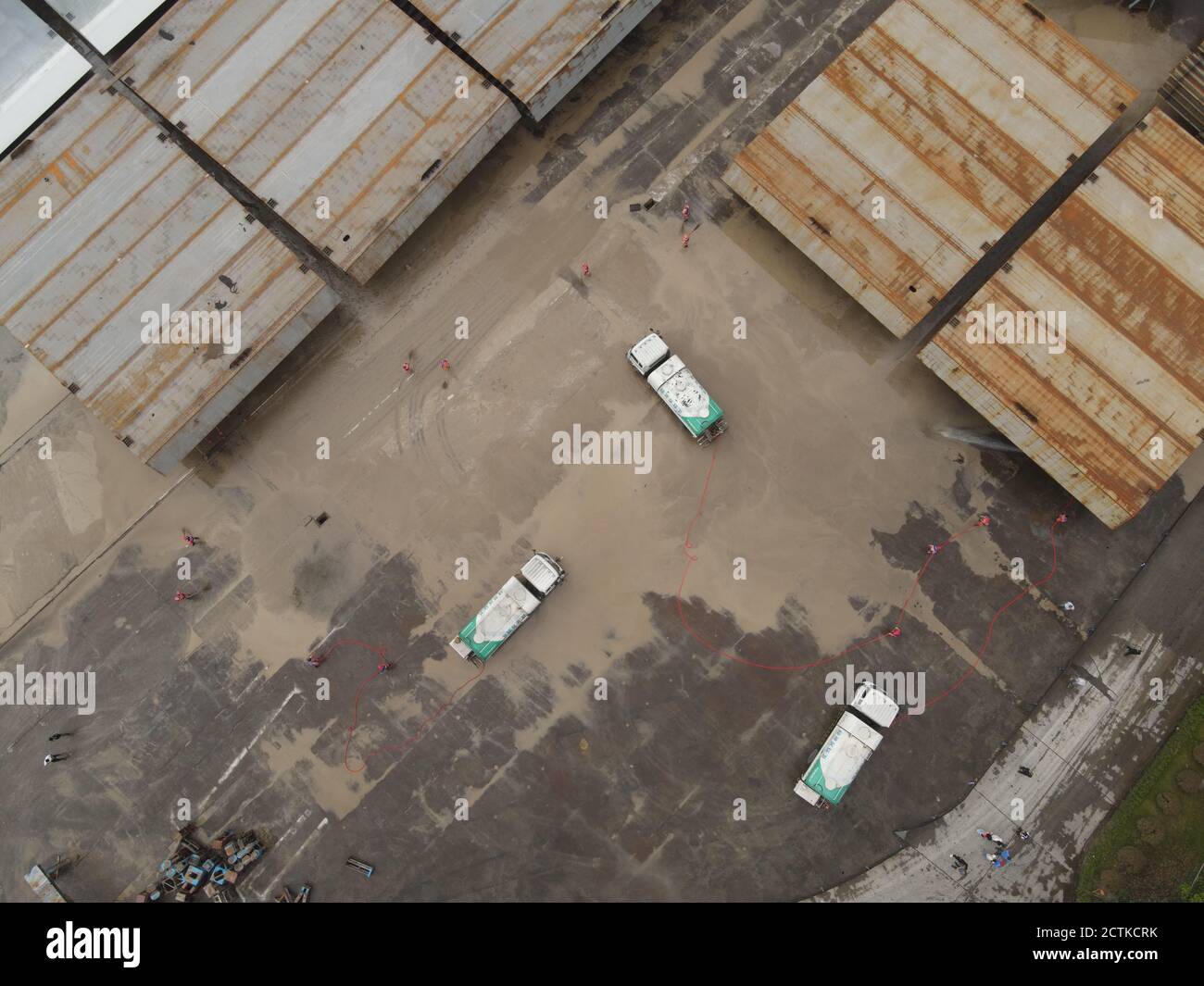 Eine Luftaufnahme von 15 Bewässerungs-LKW und einem Abfallentsorgungsstamm eingesetzt, um eine Schiffsfabrik, die durch die schwere Flut beeinflusst wurde, zu reinigen Th zu helfen Stockfoto