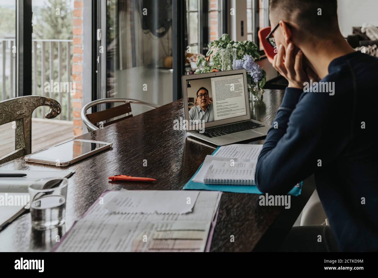 Junger Mann, der von zu Hause aus lernt, mit einem Laptop Stockfoto