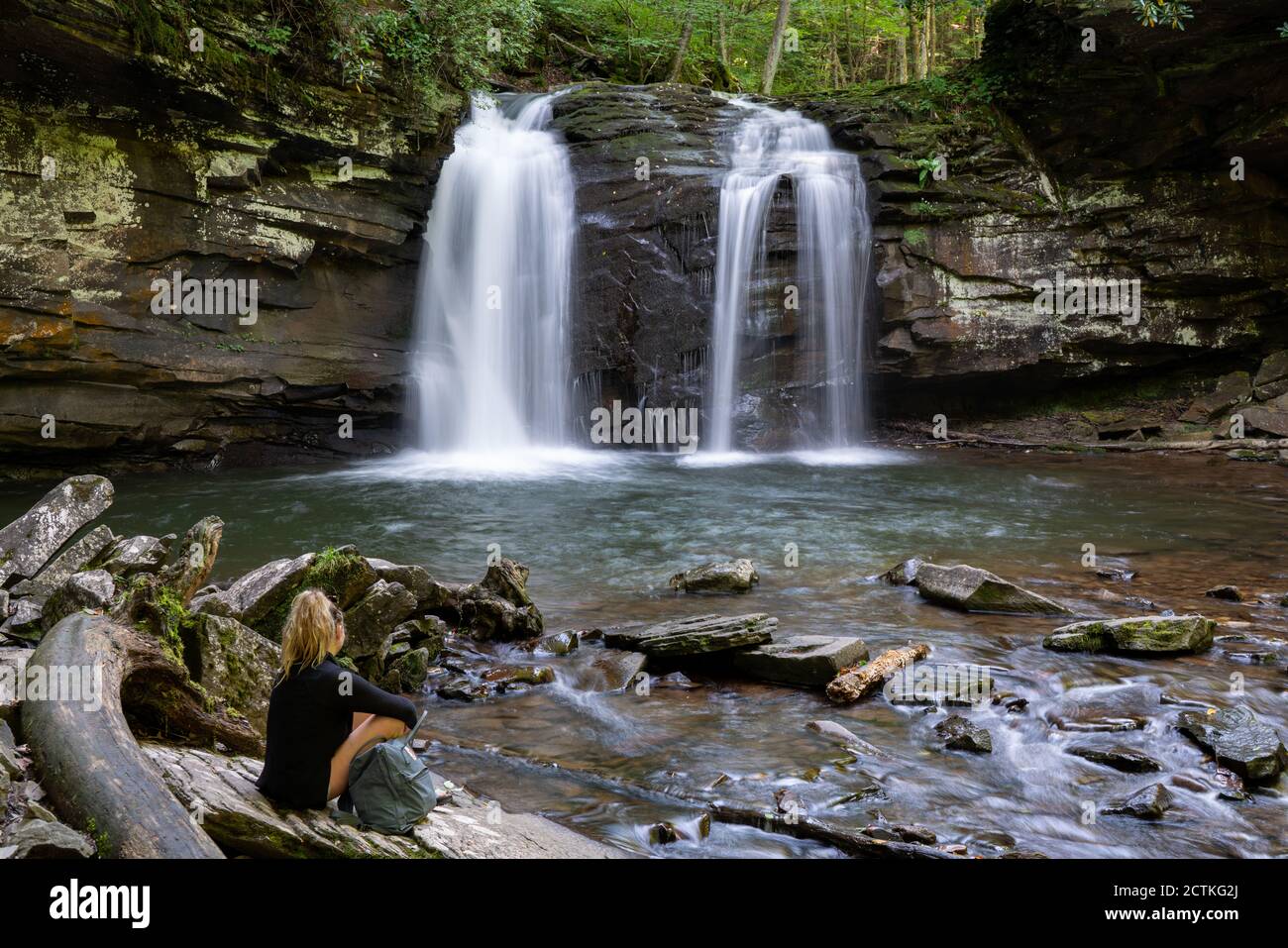 Eine Frau sitzt am Seneca Creek unterhalb der Seneca Falls im Fichte Knob/Seneca Rocks National Recreation Area, einem Teil des Monongahela National Forest in W Stockfoto