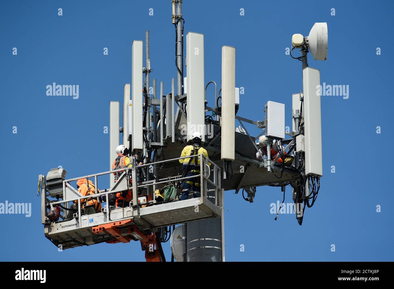 Telefoningenieure rüsten den Kommunikationsmast an der Telstra Arundel Street Exchange in Benalla, Victoria, Australien, mit neuen Geräten auf Stockfoto