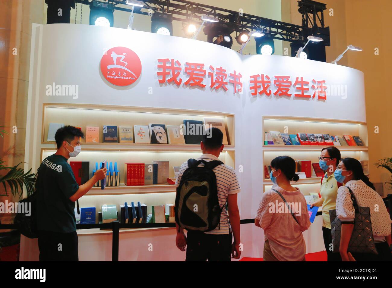 Auf der Shanghai Book Fair 2020 in Shanghai, China, am 12. August 2020 schauen sich die Menschen Bücher an einem Bücherregal an. Stockfoto