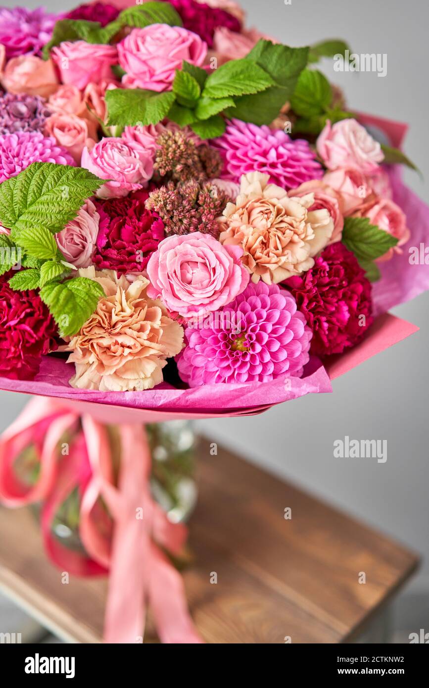 Rote Töne schönes Bouquet von gemischten Blumen. Die Arbeit des Floristen  in einem Blumenladen. Schönes frisches Bouquet. Lieferung von Blumen  Stockfotografie - Alamy