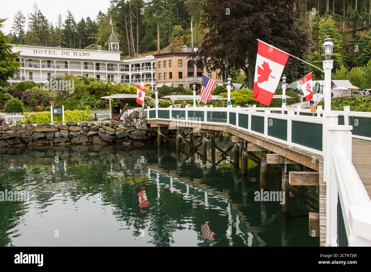 Roche Harbour, Washington, USA. Amerikanische und kanadische Flaggen säumen den Pier, der von den Docks zum Hotel de Haro führt. (Nur für redaktionelle Zwecke) Stockfoto