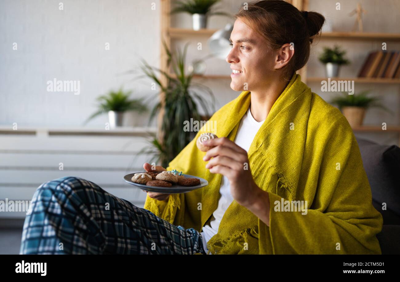 Junger Mann, der sich zu Hause entspannt. Friedliche Erholung zu Hause am Morgen Stockfoto