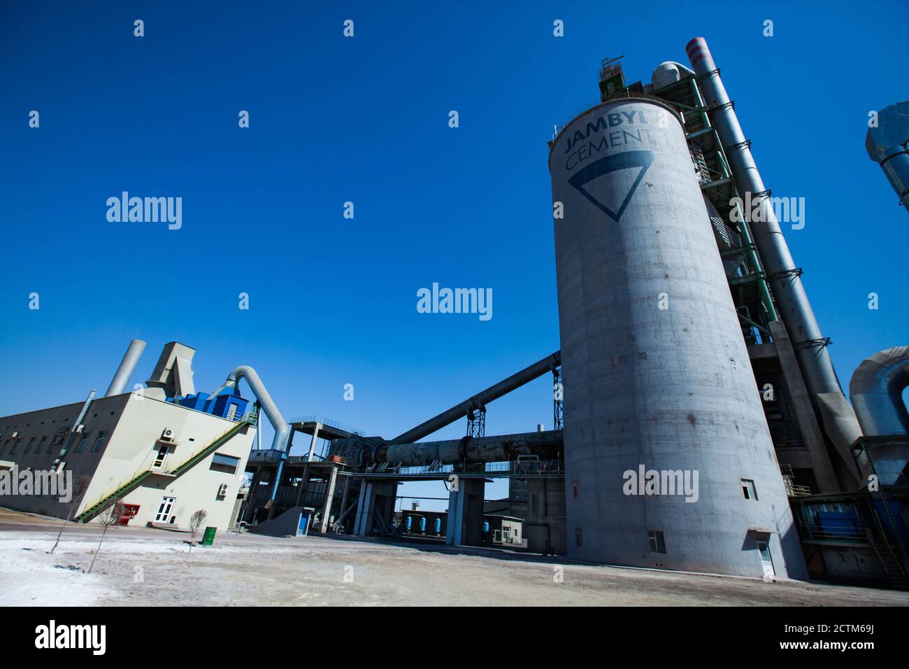 Mynaral/Kasachstan - April 23 2012: Industriegebäude der Zementanlage von Jambyl, Drehklinkerofen und Silo. Panoramaansicht mit Weitwinkelobjektiv. Stockfoto