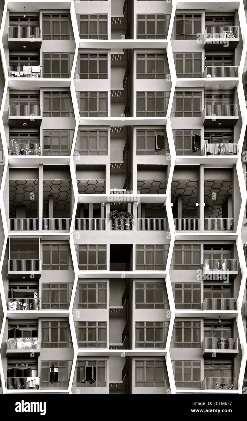 Ein moderner Apartmentblock mit sechseckigen Wabendesigns an der Fassade von Balkonen und Fenstern. Stockfoto