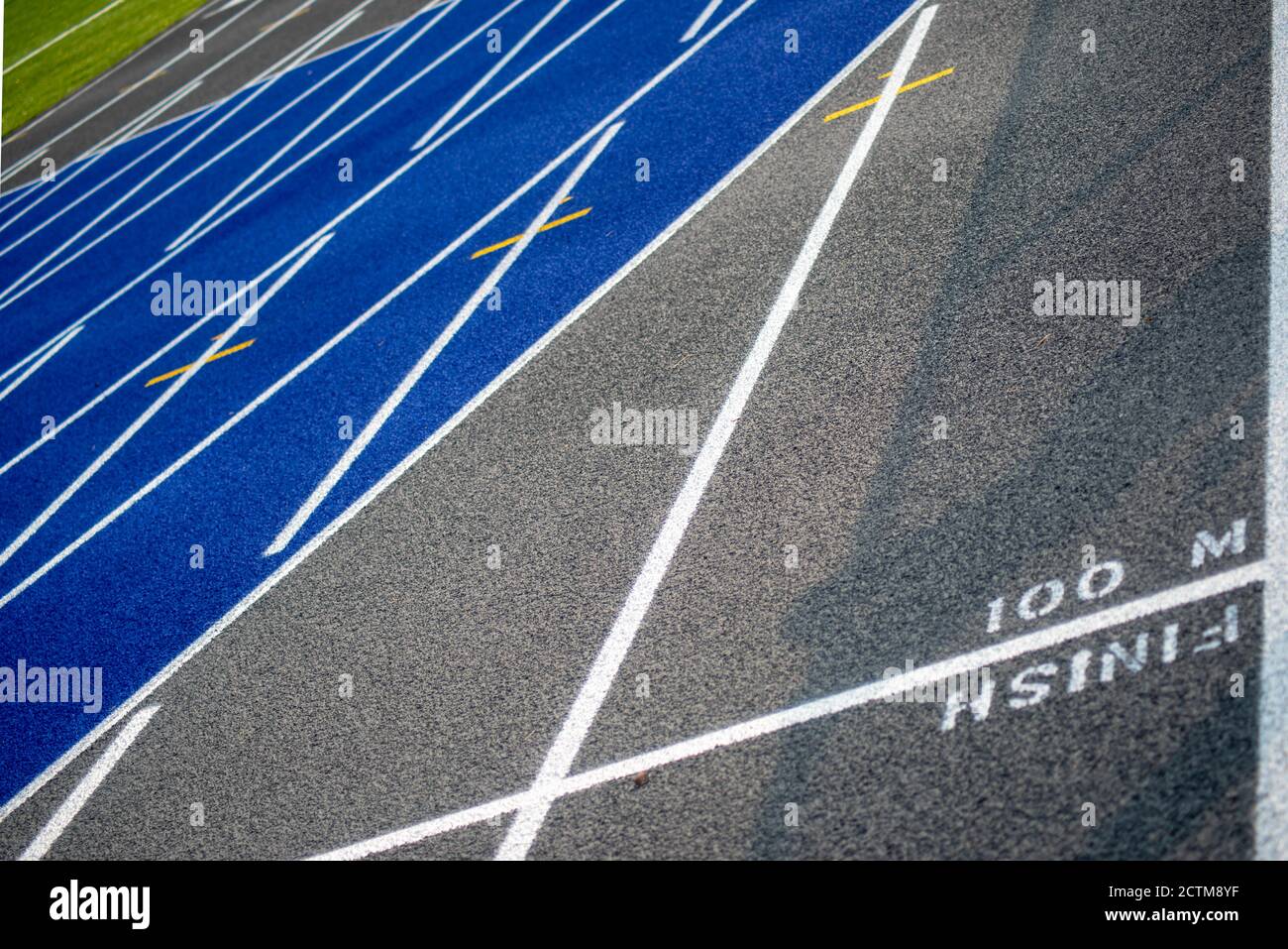 100 M Finish Line Marker auf texturierten blau und grau Laufstrecke Stockfoto