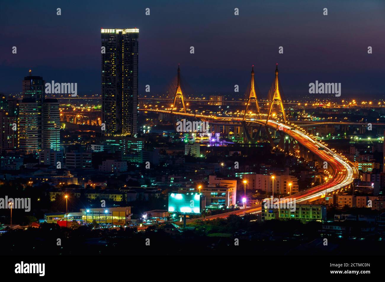 Langgeschwindigkeitsfoto des Industrial Ring Expressway und der Bhumibol Bridge. Stadtbild Bangkok bei Nacht, Gebäude im zentralen Geschäftsviertel. Stockfoto