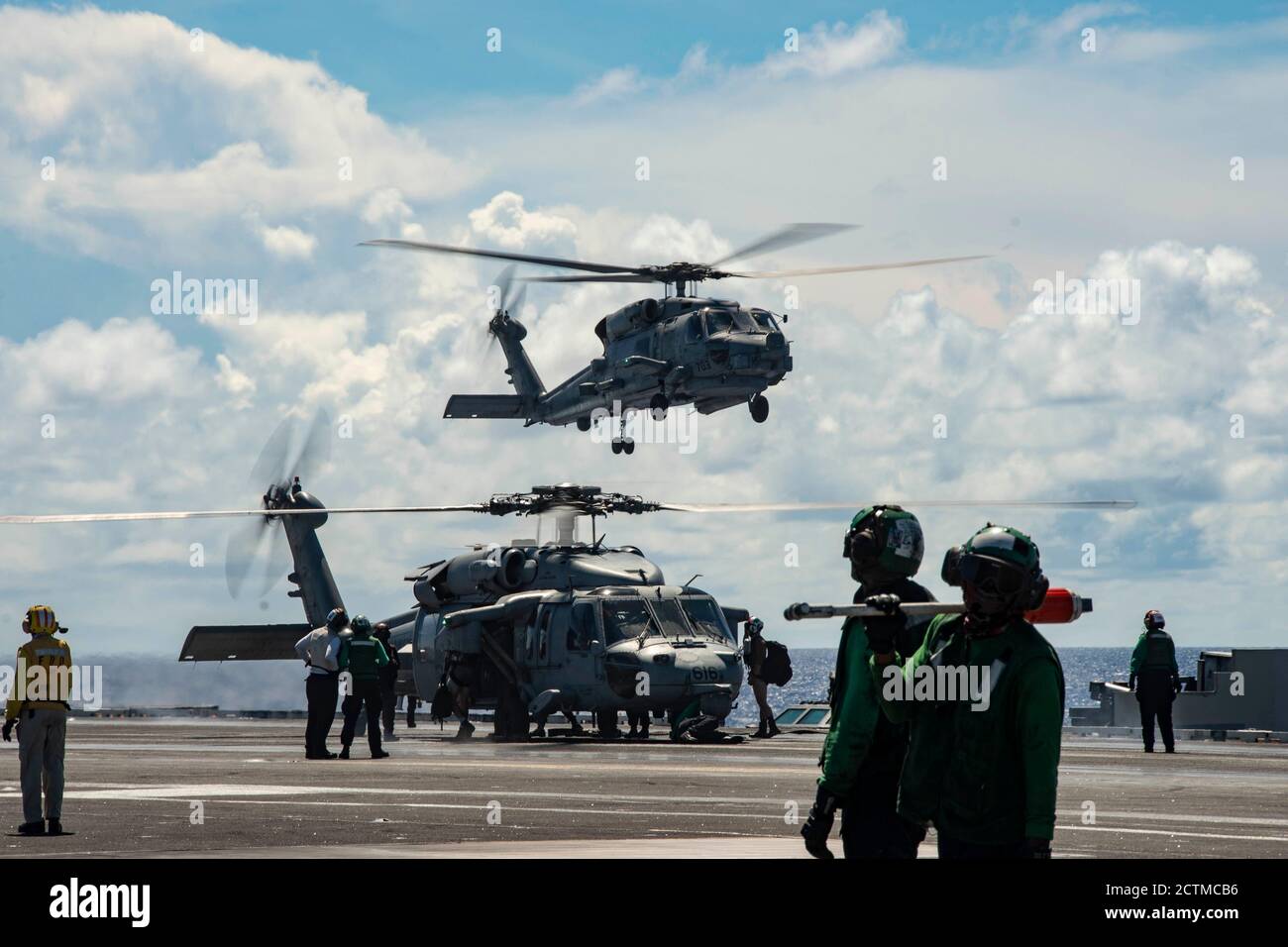 200923-N-DL524-1172 PHILIPPINE SEA (SEPT 23, 2020) ein MH-60S Seahawk, der an die Golden Falcons of Helicopter Sea Combat Squadron (HSC) 12 angeschlossen ist, führt einen Besatzungswechsel als MH-60R Sea Hawk durch, der an die Saberhawks of Helicopter Maritime Strike Squadron (HSM) 77 angeschlossen ist, Bereitet sich darauf vor, auf dem Flugdeck des einzigen vorwärts eingesetzten Flugzeugträgers der Marine USS Ronald Reagan (CVN 76) zu landen, um Valiant Shield 2020 zu unterstützen. Valiant Shield ist ein US-amerikanisches, zweijähriges Field Training Exercise (FTX) mit dem Schwerpunkt auf der Integration von gemeinsamen Schulungen in einer Blue-Water-Umgebung unter US-Streitkräften. Diese Schulung ermöglicht Stockfoto