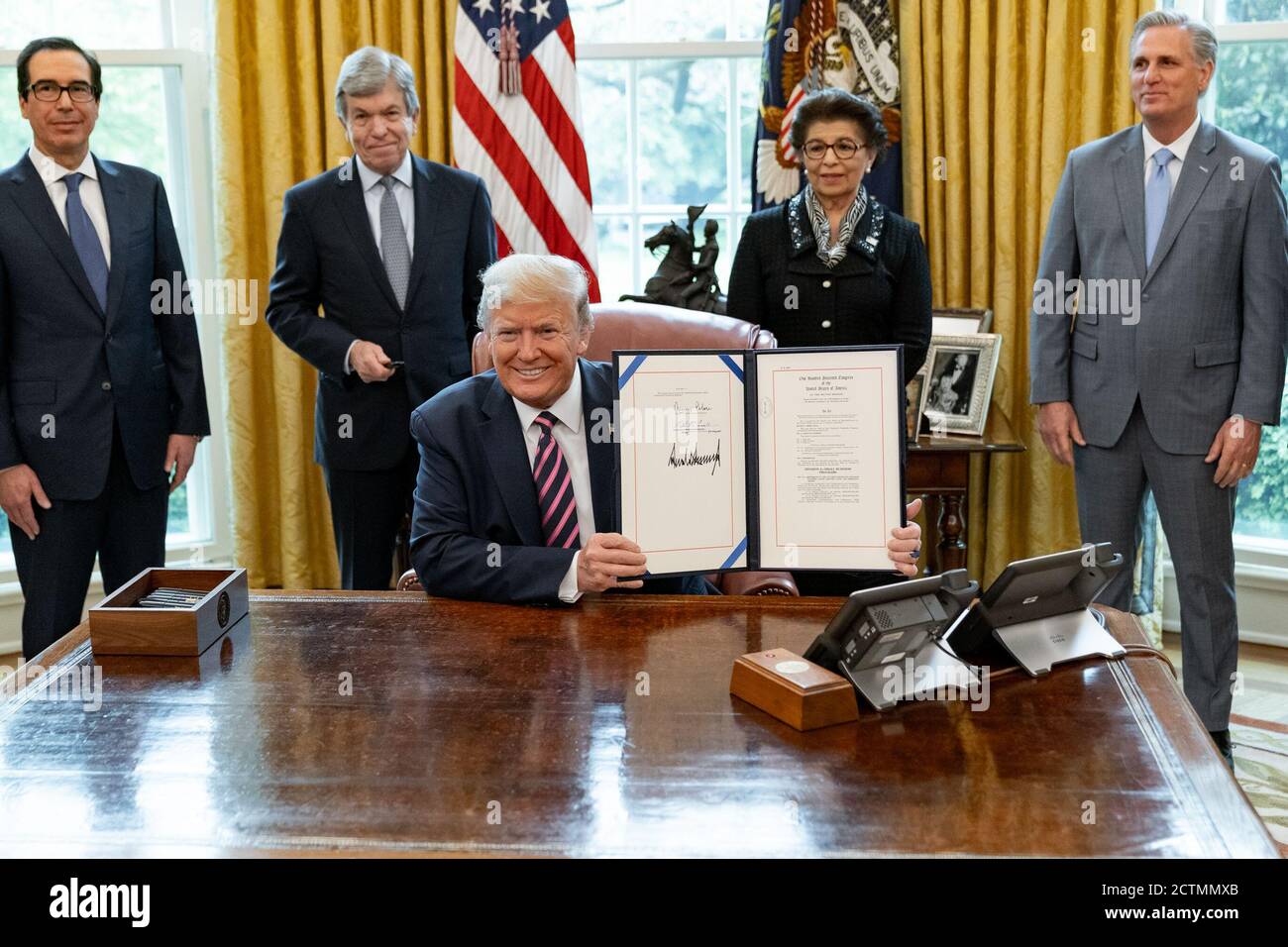 Präsident Trump unterzeichnet das Paycheck Protection Program and Health Care Enhancement Act. Präsident Donald J. Trump zeigt seine Unterschrift auf H.R. 266, dem Paycheck Protection Program and Health Care Enhancement Act Freitag, den 24. April 2020, zusammen mit Steven Mnuchin, Senator Roy Blunt, R-MO, Jovita Carranza, Verwalter der US-Small Business Administration, und Kevin McCarthy, Repräsentant der US-amerikanischen Minderheit im Oval Office des Weißen Hauses. Stockfoto