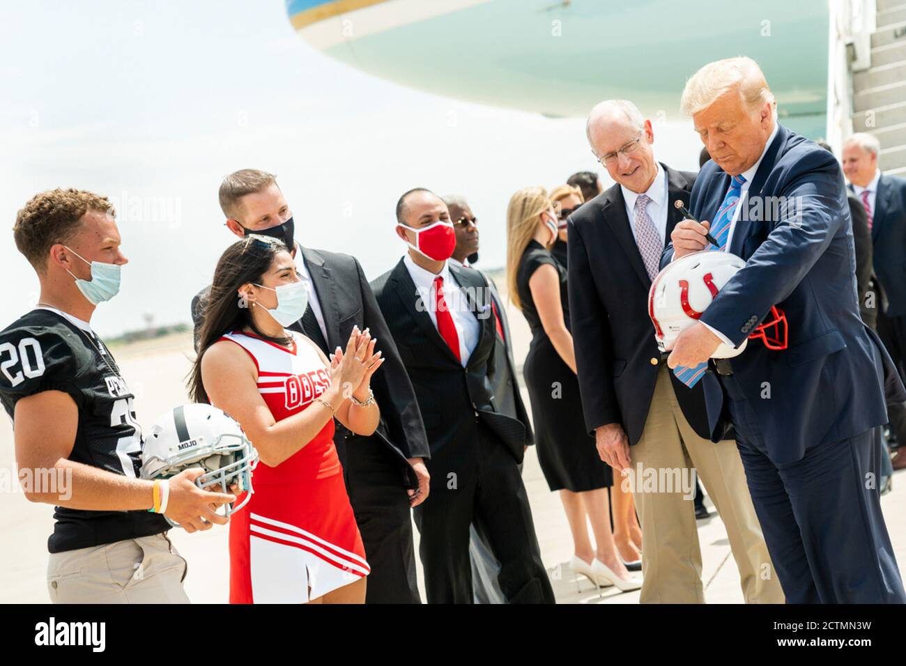 Präsident Trump reist nach Texas. Präsident Donald J. Trump unterzeichnet einen Fußballhelm für Odessa High School Cheerleader Brissa Hinojosa, zusammen mit Permian High School Football Player Harper Terry, nach der Ausschiffung Air Force One in Midland International Air and Space Port in Midland, Texas, am Mittwoch, 29. Juli 2020, wo er von Texas Gov begrüßt wurde. Greg Abbott, ehemaliger Energieminister Rick Perry, Texas Ltd.Gov. Dan Patrick, Texas Republikaner Vorsitzender Allen West, US-Vertreter Kandidaten, und Mitglieder der Gemeinschaft. Stockfoto